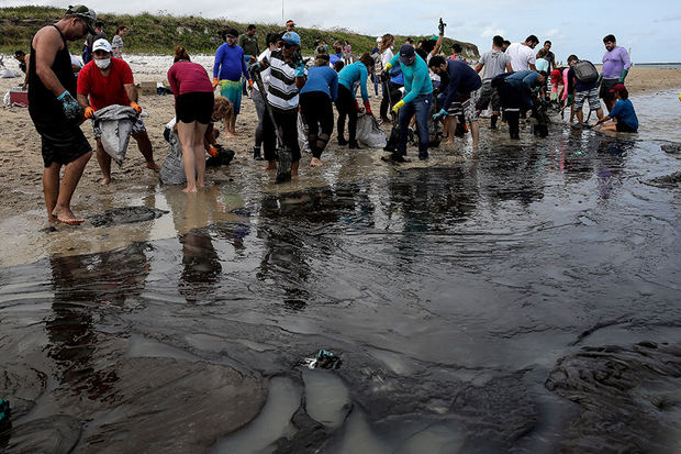 Voluntarios ayudan a eliminar la mancha de petróleo que ha llegado a la costa noreste llegando a la playa de Suape en la ciudad de Cabo Agostinho, estado de Pernambuco (Brasil). 