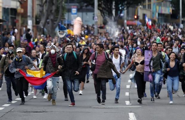 Cientos de personas marchan este lunes, durante el quinto día de protestas, en el marco del Día Internacional de la Eliminación de la Violencia contra la Mujer, en Bogotá (Colombia). 