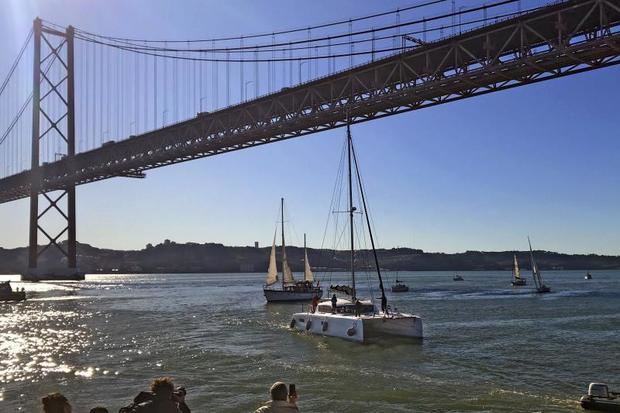 El catamarán en el que ha viajado Greta Thunberg en el momento de llegar al muelle Santo Amaro de Lisboa, tras cruzar el puente 25 de abril. Desde Lisboa partirá este martes hacia Madrid para participar en la cumbre del clima COP25. 