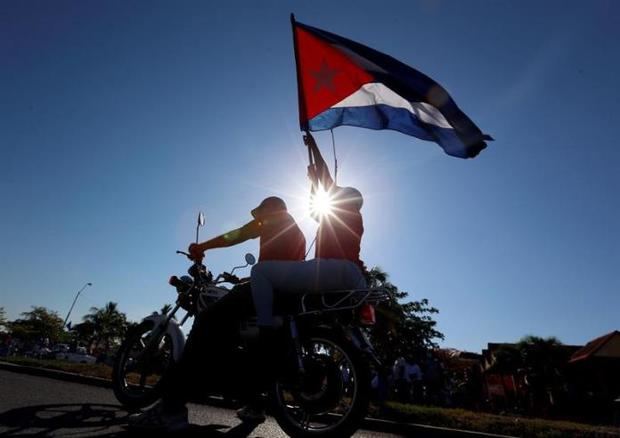 Una pareja de motoristas asiste a una regata náutica hoy, en la bahía de la provincia de Cienfuegos, Cuba.