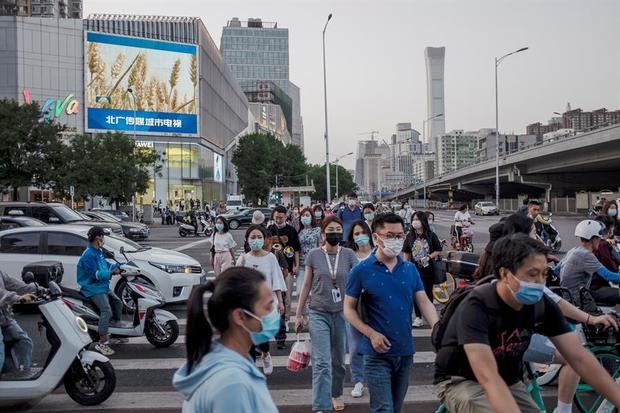 Gente con mascarilla camina por la calle en Pekín, China. 