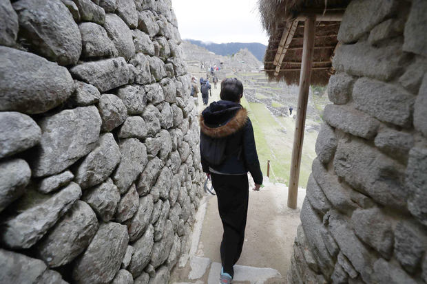 Fotografía de archivo en la que se registró a un grupo de turistas al recorrer la ciudadela inca de Machu Picchu, Perú.