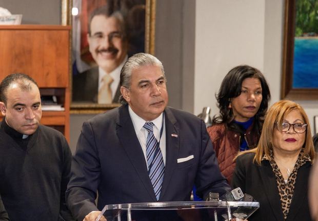 El cónsul general Carlos Castillo durante la rueda de prensa en la sede consular junto al sacerdote José Amable Mejía y Ángela López, por el Comité Altagraciano Arquidiocesano de Nueva York presidido por Ana Ozuna.
