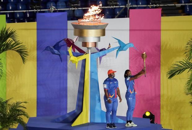 La atleta colombiana Valeria Cabezas (R) sostiene la llama olímpica durante la ceremonia de apertura de los Juegos Panamericanos Junior en el estadio Pascual Guerrero en Cali, Colombia, este 25 de noviembre de 2021. 