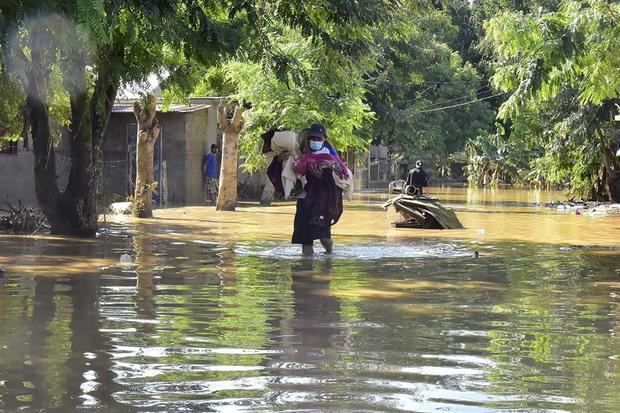 Fotografía fechada el 07 de noviembre de 2020 de vecinos de la colonia La Democracia vuelven a sus viviendas para limpiar e intentar recuperar sus pertenencias en la ciudad de El Progreso, departamento de Yoro, luego de las inundaciones provocadas por ETA en Honduras.