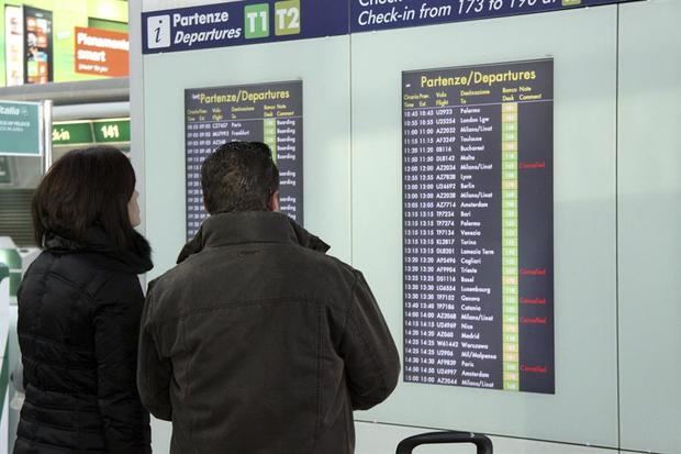 Dos viajeros comprueban la pantalla informativa en el aeropuerto de ''Leonardo Da Vinci'' en Fiumicino, Italia. 