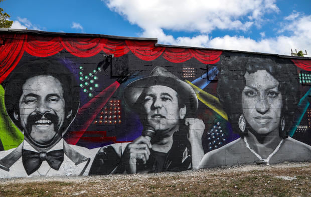 Fotografía donde se aprecia un mural con los retratos de los emblemáticos salseros (desde la izquierda) Óscar d'León, Ruben Blades y Celia Cruz pintado en el cruce entre la legendaria Calle 8 y la Avenida 19 hoy, en el barrio de la Pequeña Habana de Miami, Florida, EE.UU.
