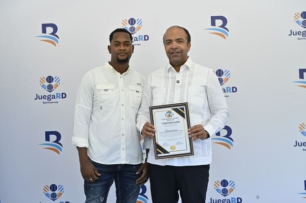 El atleta Darién King entrega una placa de reconocimiento al presidente
ejecutivo de Banreservas, Samuel Pereyra, en la inauguración de la cancha
María Luisa, remozada por la institución.