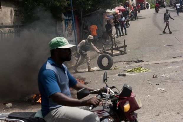 Policías recogen llantas de las barricadas durante una protesta de ciudadanos para rechazar la inseguridad y los constantes secuestros, hoy, en Puerto Príncipe, Haití.