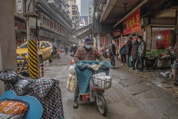 Un hombre con mascarilla protectora pasa por un mercado de una zona residencial de Wuhan, China.