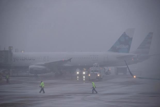 Varios trabajadores del aeropuerto asisten al despegue de un avión en Arlington, Virginia (Estados Unidos), en una fotografía de archivo.
