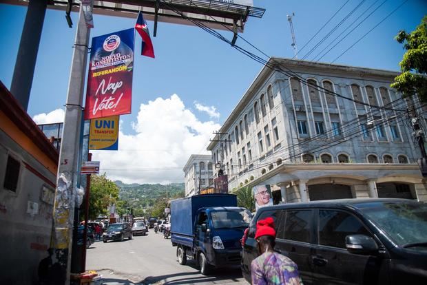 Un ciudadano camina hoy junto a un cartel que convoca a participar del referéndum que impulsa el presidente Jovenel Moise, en Puerto Príncipe, Haití.