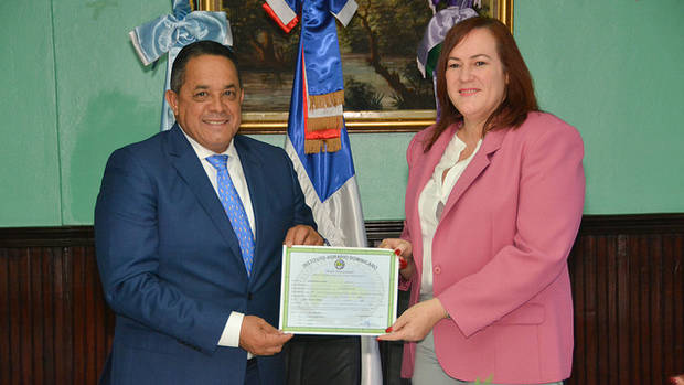 El director del IAD, Emilio Toribio Olivo y la ministra de la Mujer, Janet Camilo, al momento de la entrega del certificado del terreno, consecuencia de la alianza entre ambas instituciones para mejorar la vida de las mujeres.