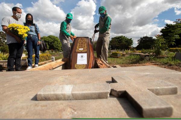 Trabajadores del cementerio Campo de Esperanza entierran una víctima de covid-19 el 3 de junio de 2020 en Brasilia (Brasil). 