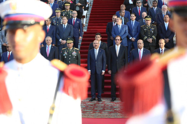 El presidente Danilo Medina, acompañado de ministros, directores generales y otros empleados del Gobierno, rindió un solemne tributo a la Bandera Dominicana, durante una ceremonia realizada en la explanada frontal del Palacio Nacional.