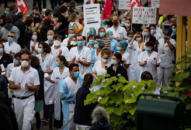 Trabajadores de la salud con mascarillas protestan en demanda de mejores condiciones frente al hospital Robert Debre en Paris, Francia.