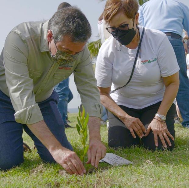Orlando Jorge Mera , ministro de Medio Ambiente y Milagros de los Santos, plantan un árbol.