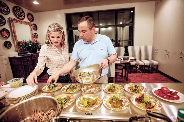 Fotografía cedida por The White House Historical Association donde aparece el cocinero Matthew Wendel mientras prepara la mesa junto a Jenna Bush para una cena del primer ministro de Dinamarca en el rancho de Crawford, y que forma parte del libro 'Recipes from the President's Ranch. Food people like to eat'.