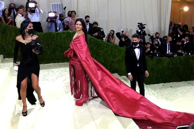 Rosalía posó en las escaleras del museo luciendo unas botas altas con plataforma y tacón transparente, unos 'shorts' y un 'top' que rodeaba sus hombros como un mantón de Manila, extendiéndose en una cola de varios metros adornada con flecos. 