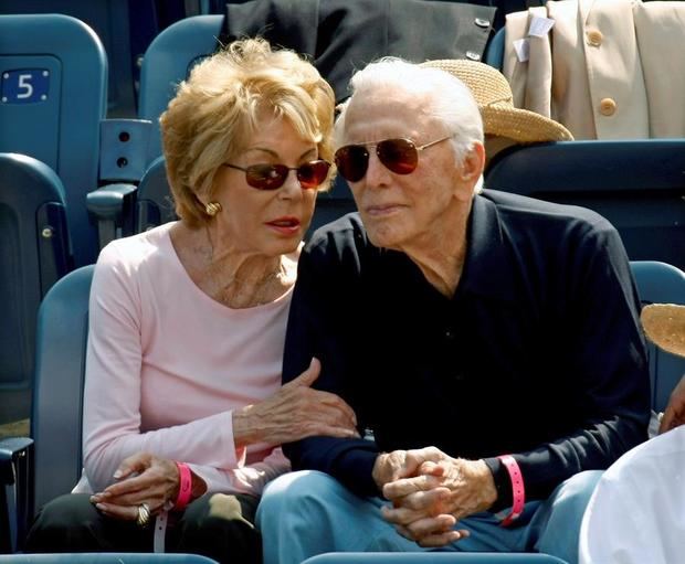 El actor estadounidense Kirk Douglas (R) se sienta con su esposa Anne Buydens (L) mientras observan a Novak Djokovic de Serbia jugando contra David Ferrer de España durante el primer partido de semifinales masculino en el decimotercer día del torneo de tenis Open de Estados Unidos 2007 en Flushing Meadows, Nueva York, EE. UU., 8 de septiembre de 2007 (reeditado el 5 de febrero de 2020). 