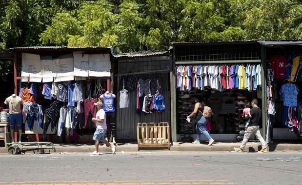 Fotografía de archivo de personas mientras caminan frente a un comercio de ropa en el mercado oriental en Managua, Nicaragua.