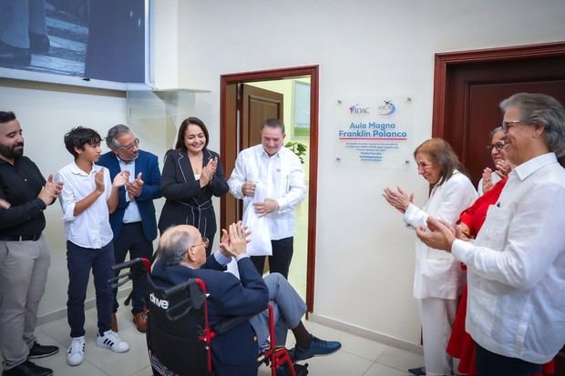 Franklin Polanco, emocionado junto a su familia, mientras el director general del IDAC, Héctor Porcella, develiza su tarja.