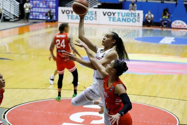 La canadiense Miranda Ayim (i) lanza un balón ante la defensa de la puertorriqueña Tayra Meléndez (d), durante un partido entre Canadá y Puerto Rico hoy por las semifinales del Campeonato FIBA AmeriCup Femenino 2021, en el Coliseo Roberto Clemente de San Juan, Puerto Rico.