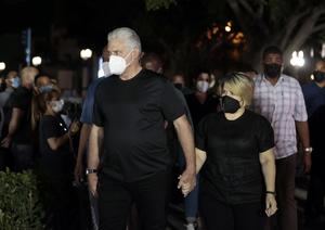 El presidente de Cuba, Miguel Diaz-Canel, y su esposa, Lis Cuesta, acuden a una vigilia como homenaje a las víctimas de la explosión del hotel Saratoga, este 13 de mayo de 2022, frente al hotel siniestrado en La Habana, Cuba.