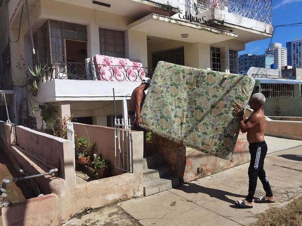 Varias personas sacan a la calles sus pertenencias tras el paso del huracán Ian, hoy en La Habana, Cuba.
