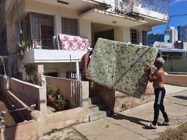 Varias personas sacan a la calles sus pertenencias tras el paso del huracán Ian, hoy en La Habana, Cuba.
