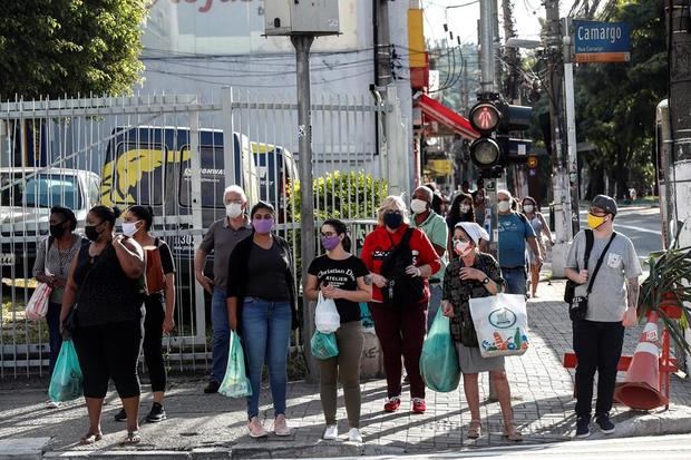 Personas con tapabocas caminan en una calle, este lunes, en la ciudad de Sao Paulo, Brasil.