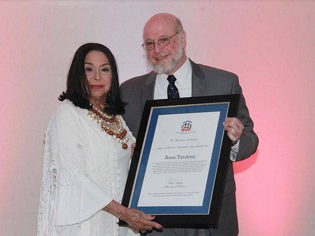 El ministro de Cultura, Pedro Vergés, hace entrega del pergamino de reconocimiento a Rosa Tavárez.