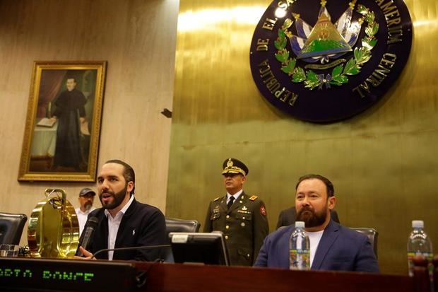 El presidente de El Salvador, Nayib Bukele (i), habla junto al diputado Guillermo Gallegos (d), del partido Gran Alianza por la Unidad Nacional, durante una sesión en el Congreso este domingo, en San Salvador, El Salvador.