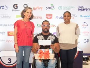Frankely Paredes, ganador de la categoría en silla de ruedas masculino, recibe su premio de manos de Karine Noetinger y Maleidy Ramírez
