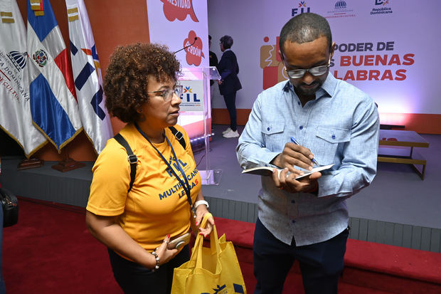 Bernabé Lagrulé firma un libro del “Método Lagrulé” a una de las asistentes al conversatorio de fitness y salud.