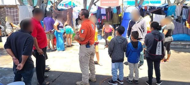 Fotografía manipulada desde su toma cedida este martes por la Secretaría de Gobernación, donde se observa a un grupo de migrantes interceptados en un campamento por elementos del Instituto Nacional de Migración, INM.