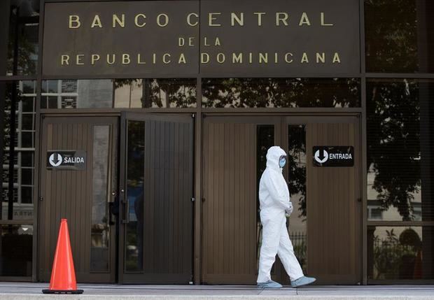 Un funcionario de sanidad controla la entrada al edificio del Banco Central este miércoles, en Santo Domingo, República Dominicana. 