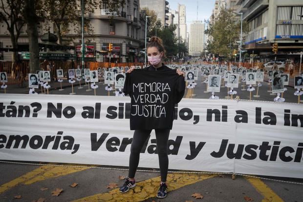 Una mujer posa frente a afiches con fotografías de los desaparecidos durante la dictadura uruguaya entre 1973 y 1985, en Montevideo.