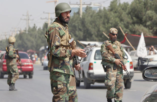 Fuerzas talibanes, con uniformes con los colores del antiguo ejército afgano, montan guardia en un puesto de control al costado de la carretera en Kabul, Afganistán.