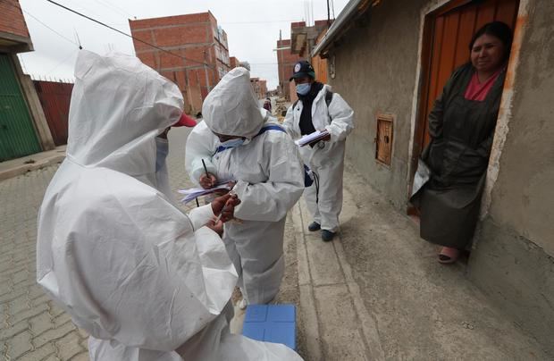Fotografía de archivo en la que se registró a una mujer al entregar sus datos a funcionarios del sector salud, antes de recibir en su casa una dosis de la vacuna contra la covid-19, en El Alto, Bolivia.