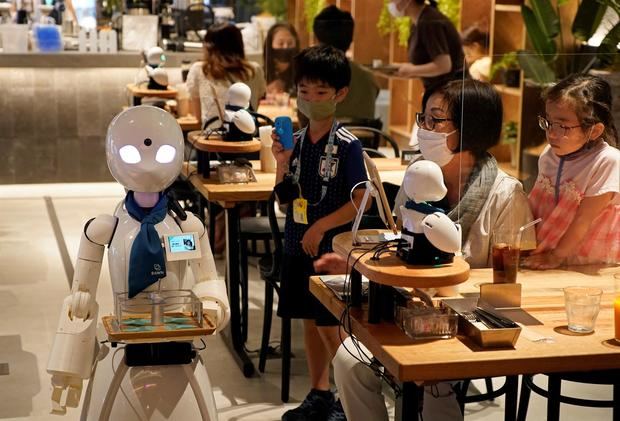 Un robot se mueve entre las mesas en el café DAWN ver.β de Tokio.