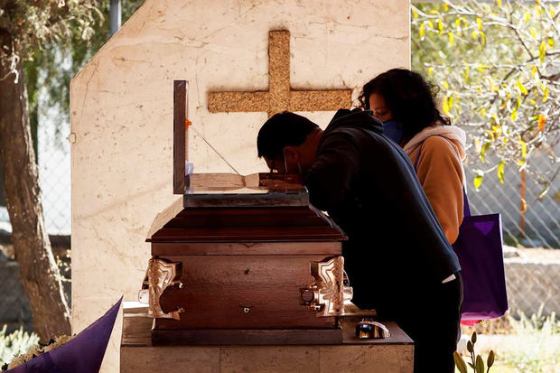 Familiares asisten al entierro de un fallecido por Covid-19 el 21 de enero de 2021, en el Panteón de Tlahuac, en Ciudad de México, México.