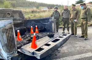 Carabineros y su director Ricardo Yáñez inspeccionan un vehículo policial quemado en el lugar donde fueron asesinados tres carabineros en la zona rural de Canete.