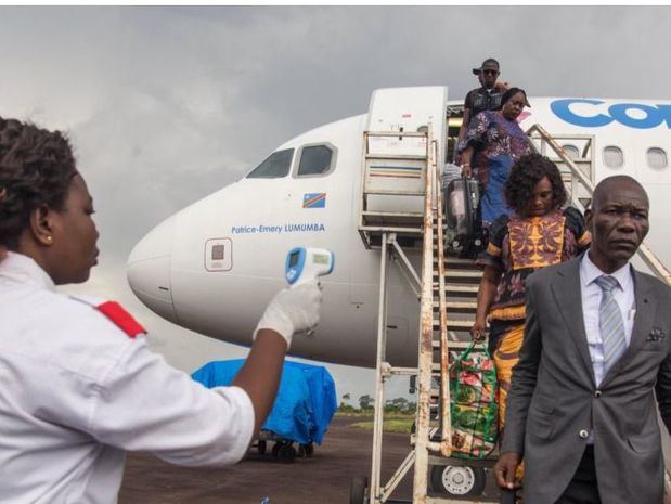 Una funcionaria de salud usa un termómetro para evaluar a los pasajeros que llegan al aeropuerto de Mbandaka, en la República Democrática de Congo. 