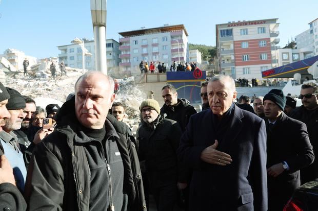 El presidente Recep Tayyip Erdogan (dcha) visita la zona de edificios colapsados en Hatay, Turquía.