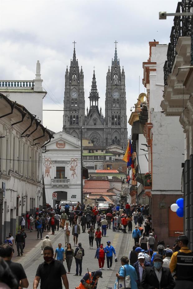 Personas caminan hoy por el centro histórico, cerca a la Basílica del Voto Nacional, en Quito, Ecuador.