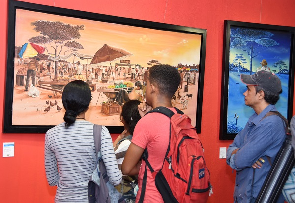 Jóvenes estudiantes aprecian una obra expuesta en una edición de la Serie Valores de las Provincias, en el Centro Cultural Banreservas