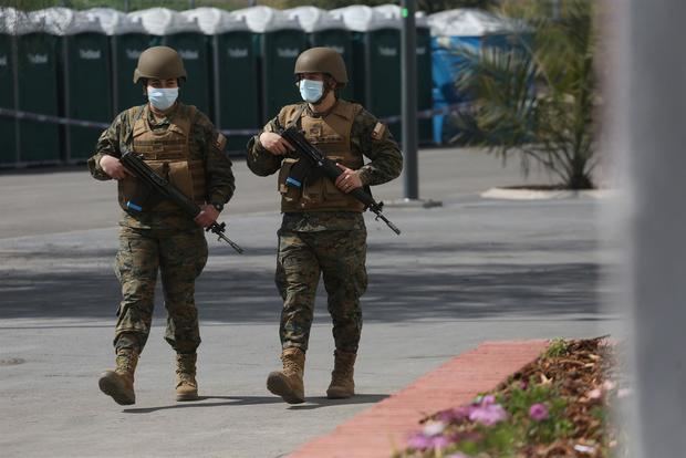 Soldados prestan guardia mientras se instala un colegio electoral para el plebiscito constitucional hoy, en el Estadio Nacional de Santiago, Chile.