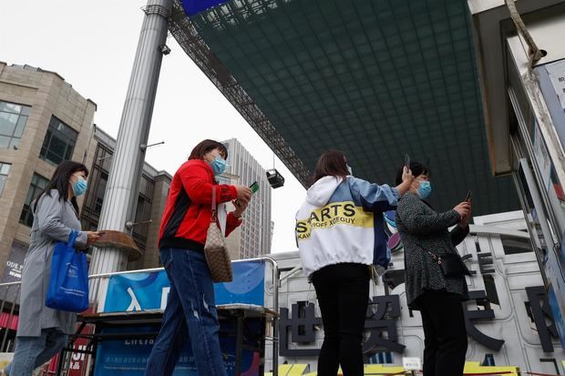 Las personas escanean un código QR y muestran en su aplicación su estado de salud antes de entrar en un establecimiento en Pekí, China.