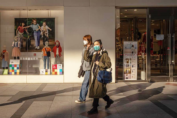 Personas con mascarillas caminan en un centro comercial, en Pekín, China.